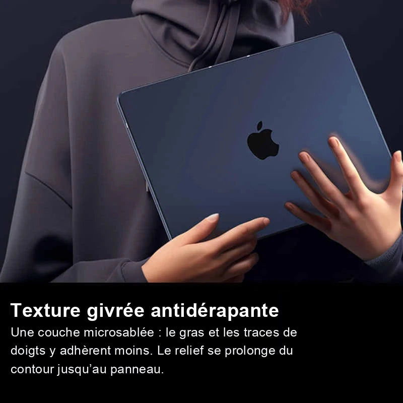 Personne en sweat gris tenant à deux mains un MacBook bleu nuit dans sa coque givrée.