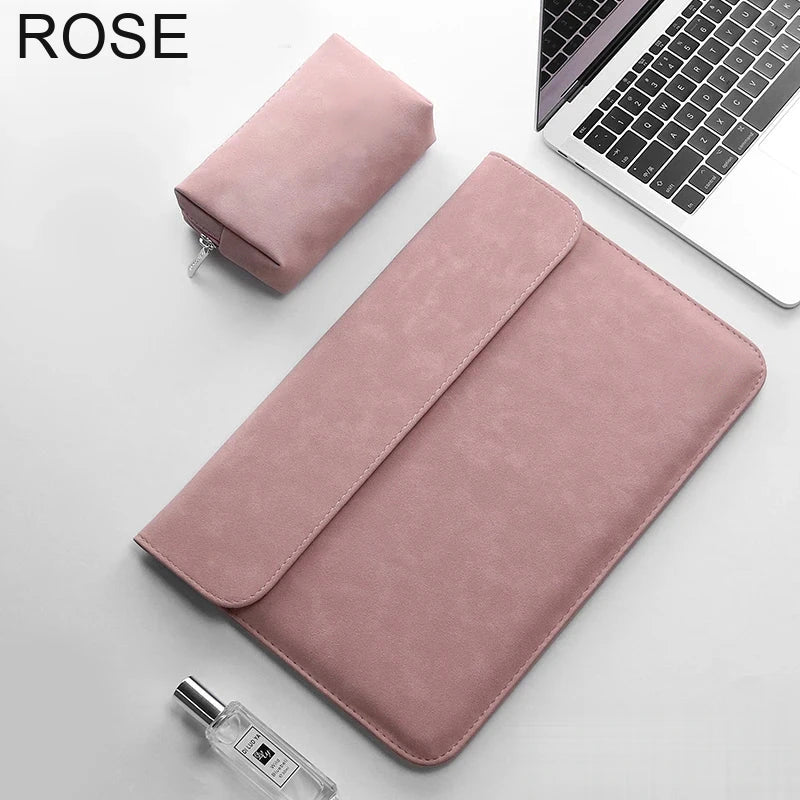 Pochette ordinateur rose en simili cuir, rabat fermé, posée en biais sur un bureau avec sa trousse assortie et un ordinateur portable.