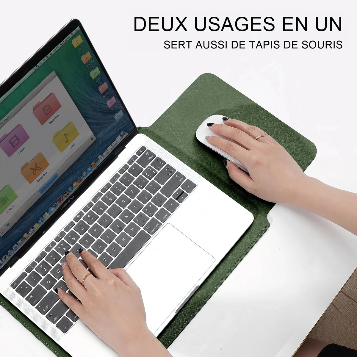 Housse en simili cuir vert kaki dépliée en tapis de bureau, une main sur la souris à côté d'un ordinateur portable ouvert.