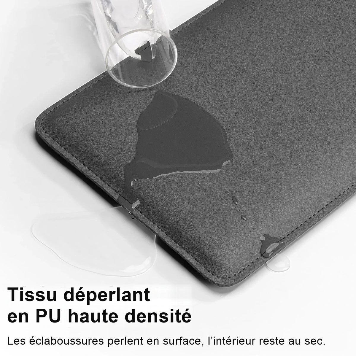 Housse d'ordinateur en PU gris anthracite vue de dessus, de l'eau versée d'un verre perle à sa surface sans la traverser.