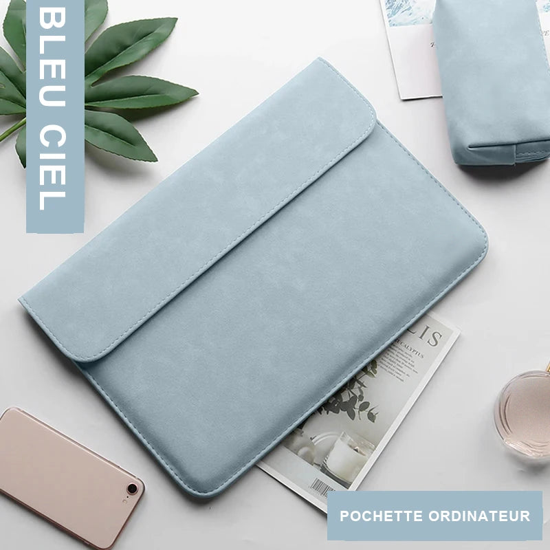 Pochette ordinateur bleu ciel en simili cuir vue de dessus sur un bureau clair, entourée d'une trousse assortie, d'un téléphone et d'un magazine.