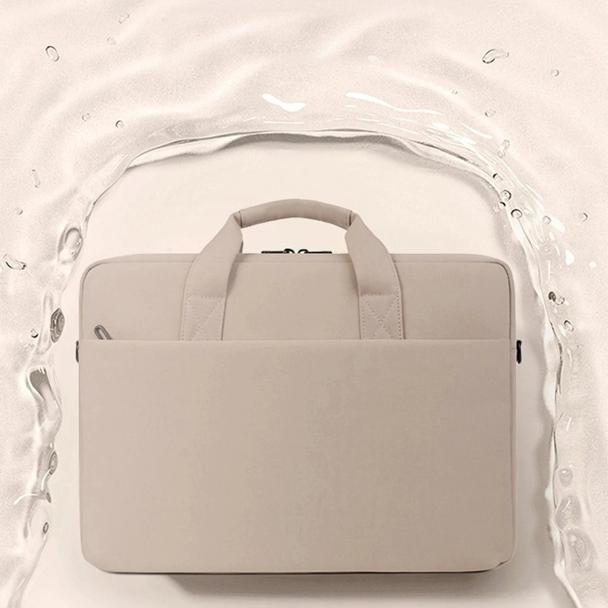 Sacoche à ordinateur beige en nylon, poignées souples et grande poche avant, posée au centre d'une éclaboussure d'eau