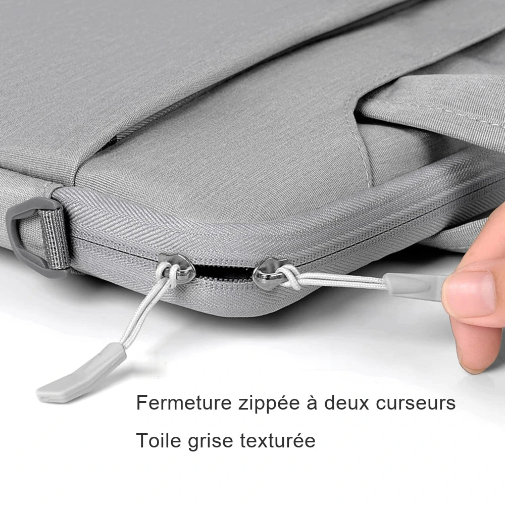 Sac ordinateur gris en toile texturée, fermeture zippée à deux curseurs avec cordon et tirette, posé sur fond studio blanc.