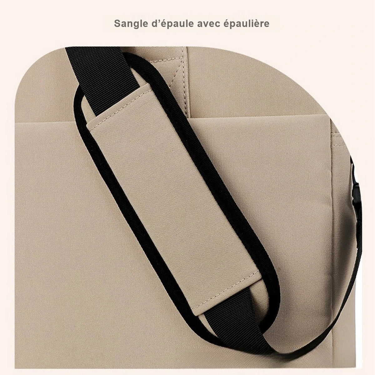 Gros plan sur la sangle d'epaule noire et son epauliere beige, sur la toile beige d'un sac ordinateur.