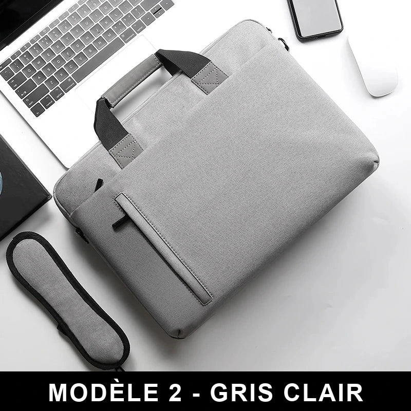 Sacoche à ordinateur portable en toile gris clair, vue de dessus sur un bureau, avec sa poignée et sa bandoulière matelassée.