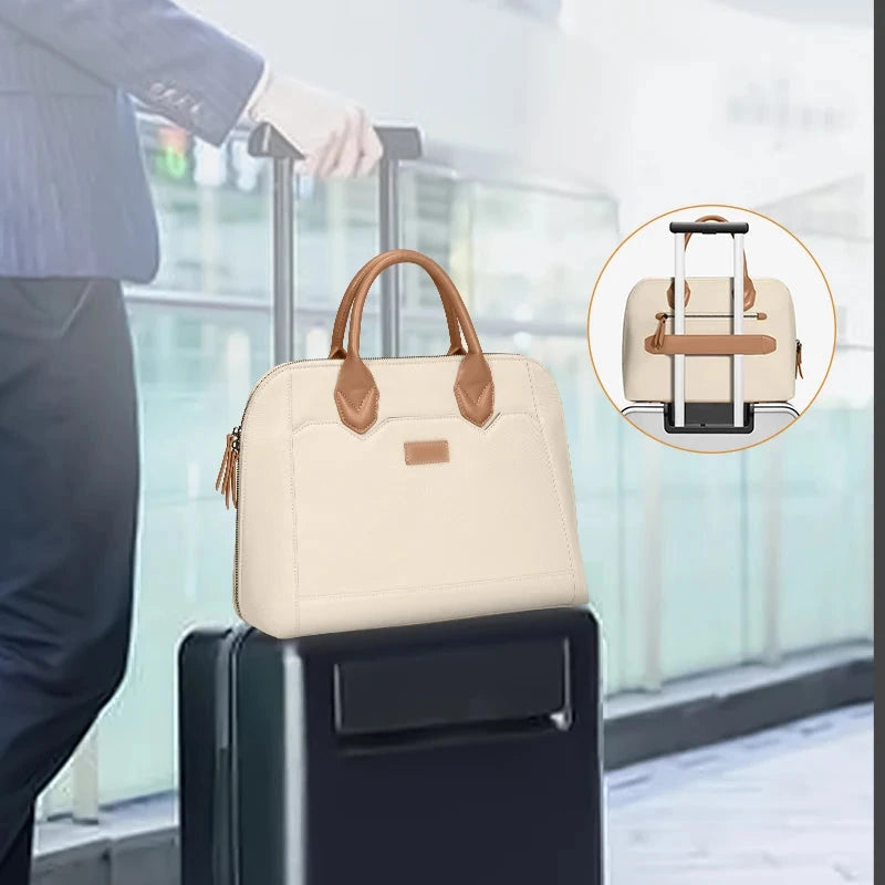 Sacoche ordinateur creme posee sur une valise dans un hall d'aeroport, avec un encart montrant le dos du sac et son passant de trolley.