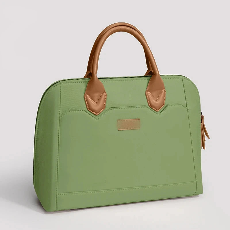 Sac à main vert pour ordinateur portable, anses arrondies en simili cuir fauve, fermeture zippée et poche avant à rabat.