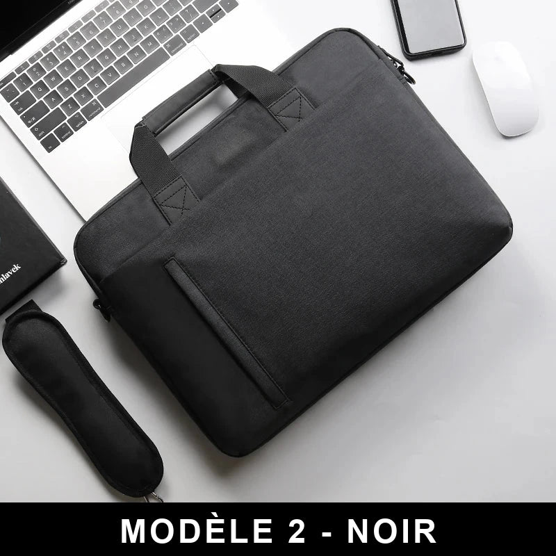 Sacoche noire pour ordinateur portable, poignée matelassée et bandoulière, posée à plat sur un bureau blanc avec un smartphone et une souris en arrière-plan.
