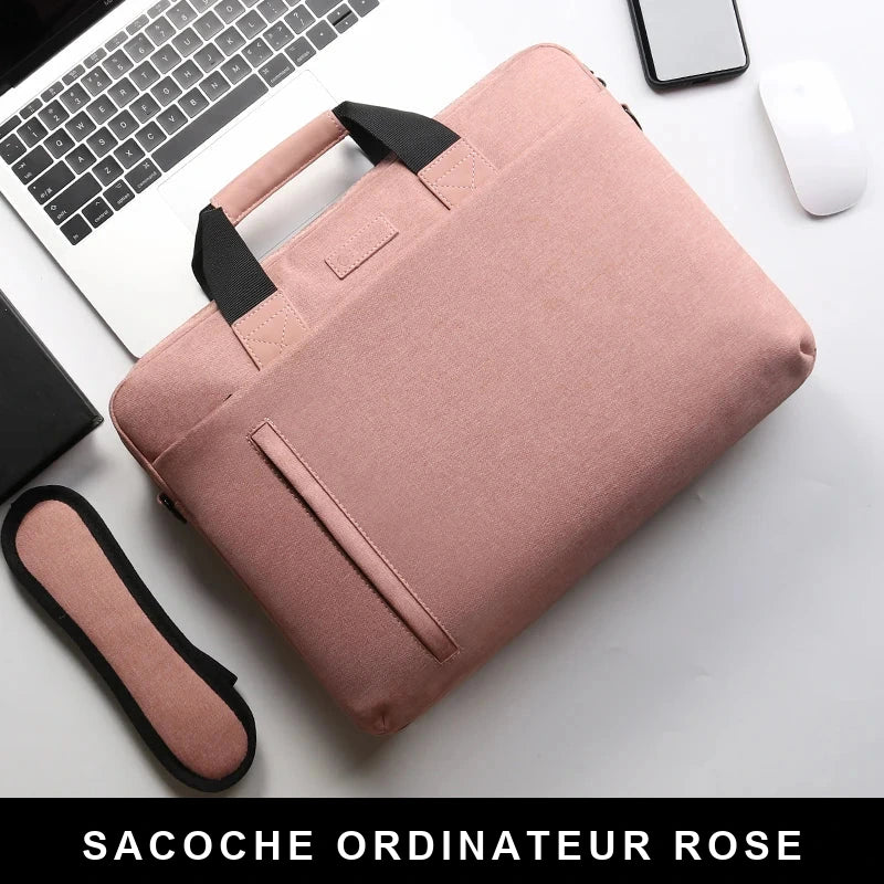 Sacoche ordinateur rose vue de dessus, poignées noires et poche zippée sur le devant, posée près d'un clavier d'ordinateur.