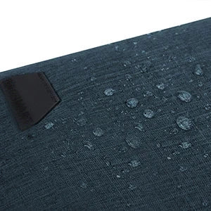 Gros plan du tissu bleu deperlant de la sacoche, perle de gouttes d'eau, avec une etiquette noire cousue pres du bord.