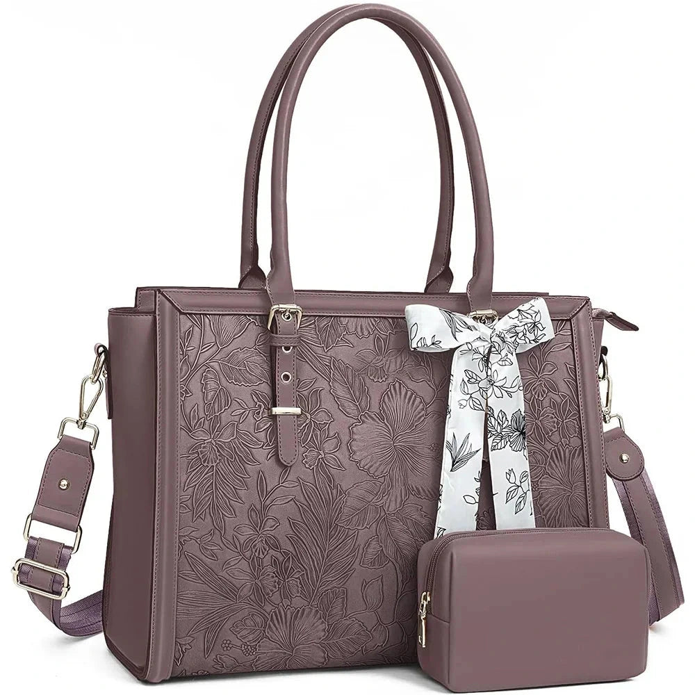 Sac ordinateur prune en simili cuir gaufré à motif floral, avec sa bandoulière, son foulard noué et sa trousse assortie posée devant.
