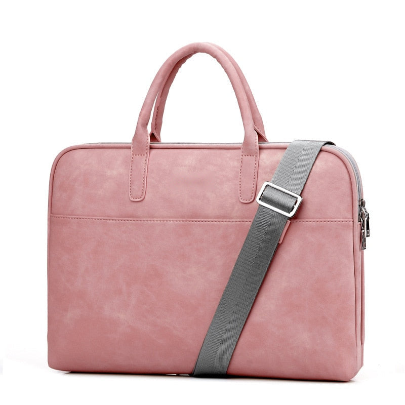 Sacoche pour ordinateur portable en simili cuir rose, vue de face, deux anses et bandoulière grise réglable à boucle métallique.