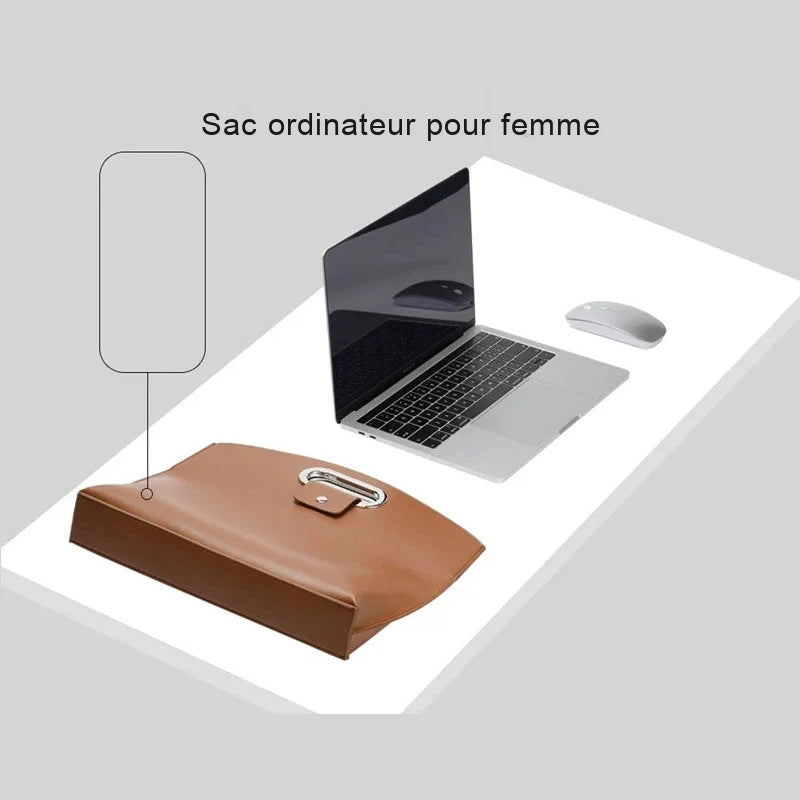 Sac ordinateur cognac posé à plat sur un bureau blanc, à côté d'un ordinateur portable ouvert et d'une souris, vu de trois quarts.